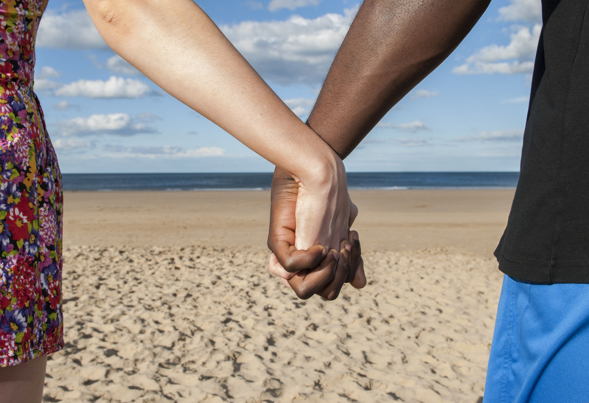 Two hands holding at the beach two hands holding on the beach
